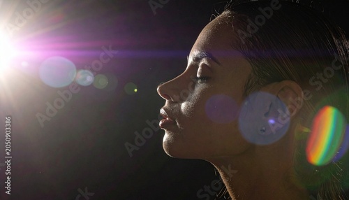 Profile of woman, illuminated, surrounded by lens flare