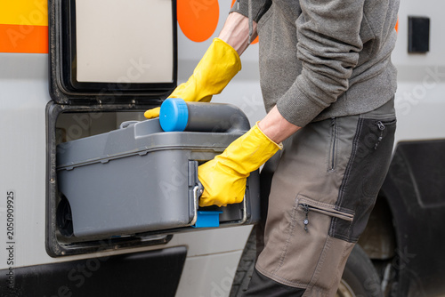 Emptying portable cassette toilet from campervan during campsite sanitation maintenance