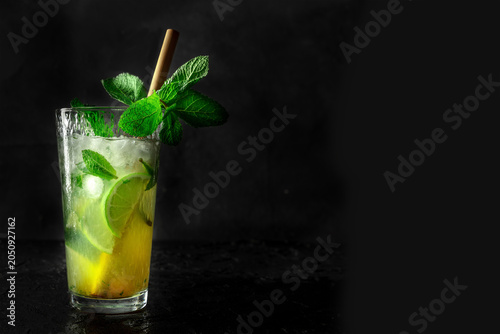 Mojito, summer cocktail with mint, lime, and ice, side view of a single glass