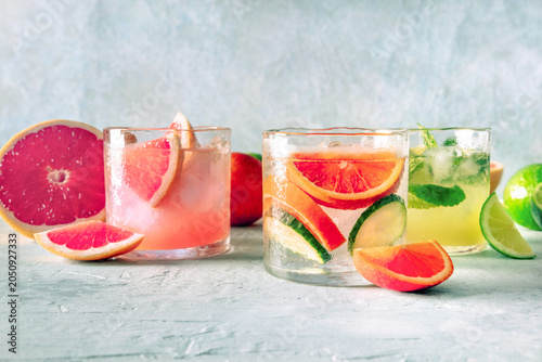 Refreshing summer cocktails with ice cubes on a light background