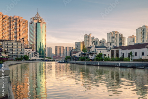 Golden Sunset Reflections over Suzhou Creek and Modern Residential Buildings in Shanghai, China.