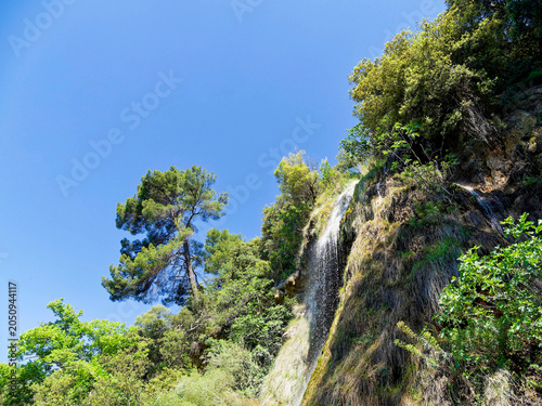 The high waterfall of Villecroze in the Haut Var plunges from a tufa cliff, continuing its course into a stream in the middle of the park