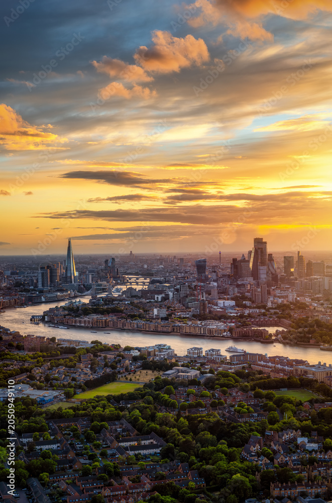 Obraz premium High, panoramic view of London in England during a summer sunset with beautiful cloudscape and golden sunlight