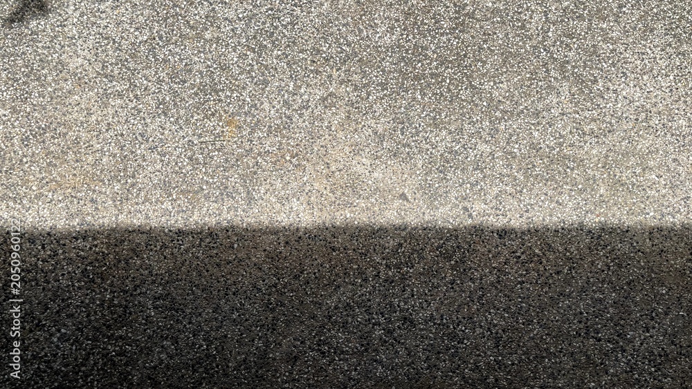 Fototapeta premium Modern abstract background of sharp dark shadows and bright sunlight on textured concrete surface with copy space.