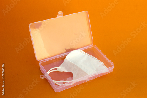 Bild auf Leinwand A white mask inside a clear plastic box