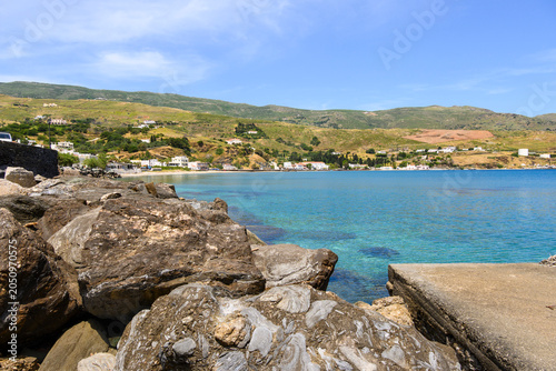 Rocks and crystal clear waters next to Andros Town. Andros Island, Cyclades, Greece