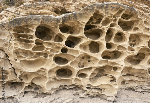 Obraz na plátně Large sandstone rock formation with numerous natural holes and pits created by w