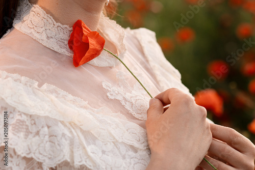 girl holds a poppy flower close up