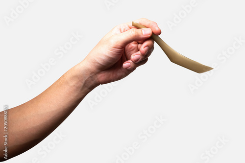 Male hand holding a gold plastic spoon isolated on white background.