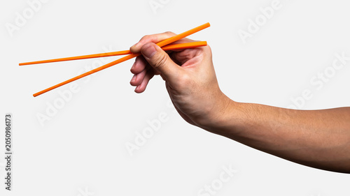 Male hand holding a orange plastic chopstick isolated on white background.