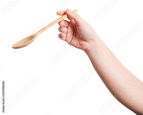 Female hand holding a wooden spoon isolated on white background.
