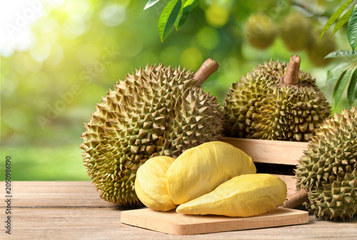 Foto Durian fruit on wooden table with blur durian plantation background