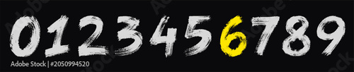 Fotografi Handwritten numbers from 0 to 9 with the number 6 highlighted in yellow, set against a dark textured background