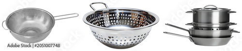 Foto Three stainless steel kitchen strainers and a stack of pots and pans isolated on