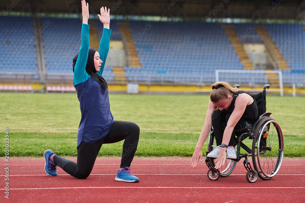 Naklejka premium Adaptive Fitness Training On Track With Wheelchair Athlete And Coach Stretching Together