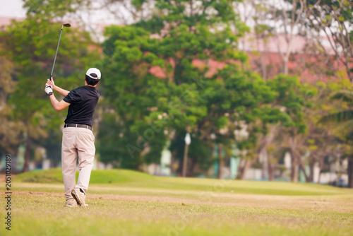 Cuadro en lienzo Male golfer finishing his swing on a lush green golf course