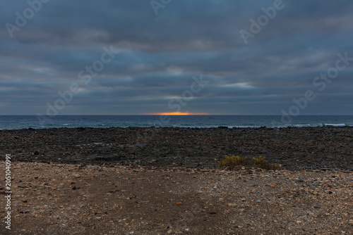 Bleak Coastal Industrial Wasteland Under Heavy Dramatic Clouds with Twilight Horizon Light