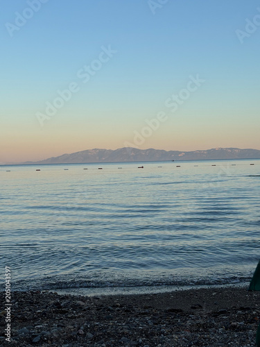 Golden sandy beach and crystal-clear turquoise sea in Bodrum, Turkey. Beautiful coastal landscape with calm waves, sunny weather, and a relaxing Mediterranean vacation atmosphere.