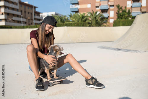 Young woman with cute little dog in skate board place. Madrid, Spain.