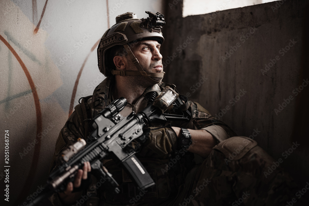 Obraz premium Military soldier Hide in a shelter with assault rifle, tactical operator in urban combat mission