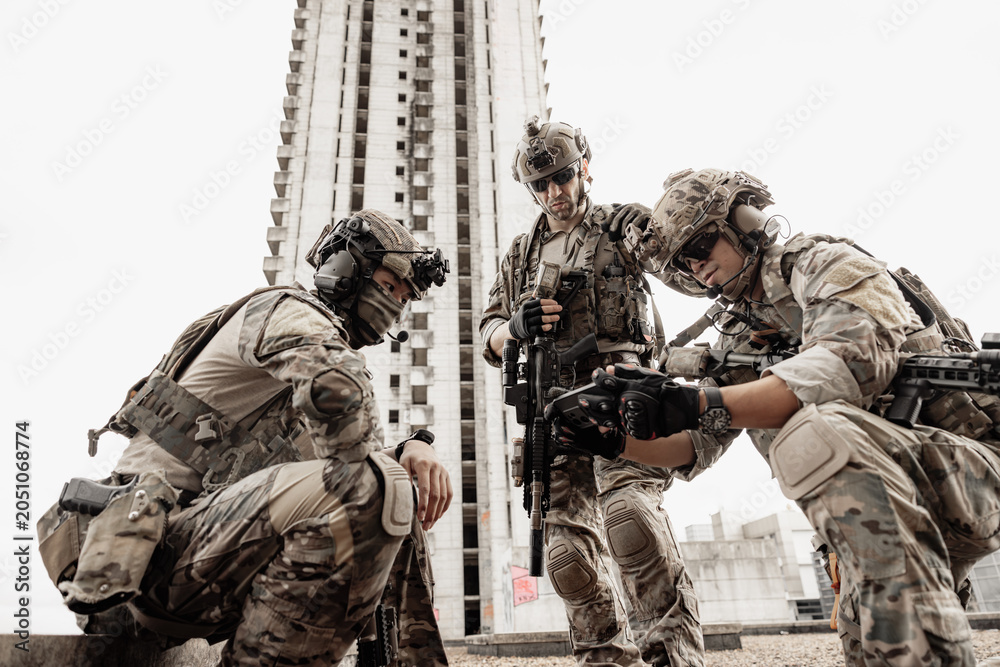 Obraz premium Group of Military Team, Soldiers in camouflage plan attack mission together against the building