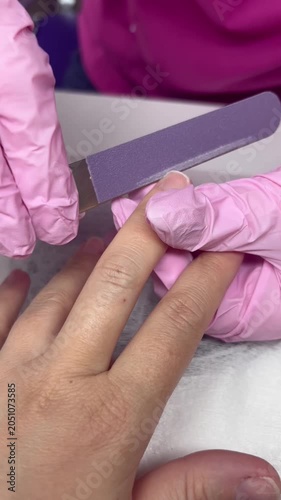 Manicure. Close-up of a girl's fingers and nails during a manicure. Filing her nails with a nail file.