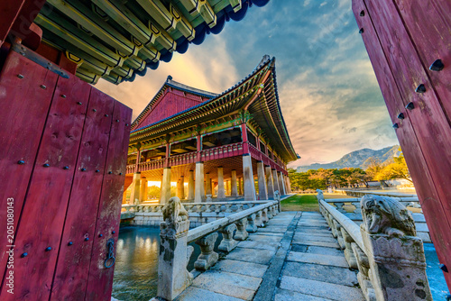 Foto Beautiful view of Gyeonghoeru Pavilion in Gyeongbokgung Palace at sunset, looking through traditional red wooden gates with an ancient stone bridge in the foreground, Seoul, South Korea