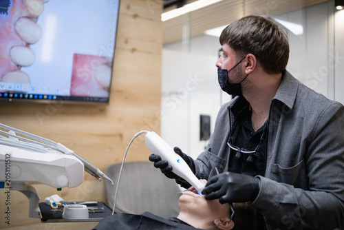 Bild auf Leinwand Dentist operating an intraoral scanner on a patient's mouth, capturing detailed