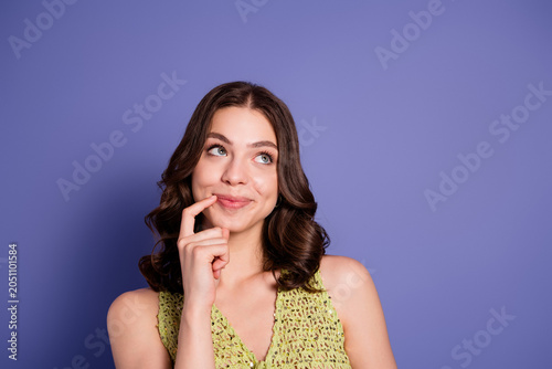 Foto Young woman in green top looking thoughtful and playful while glancing upward ag