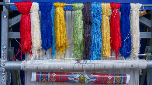 Konstfotografi Yarn bundles, colorful skeins of silk or wool thread on metal bar of rug-weaving loom with talim