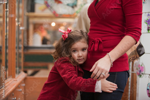 Young girl clinging to her mother
