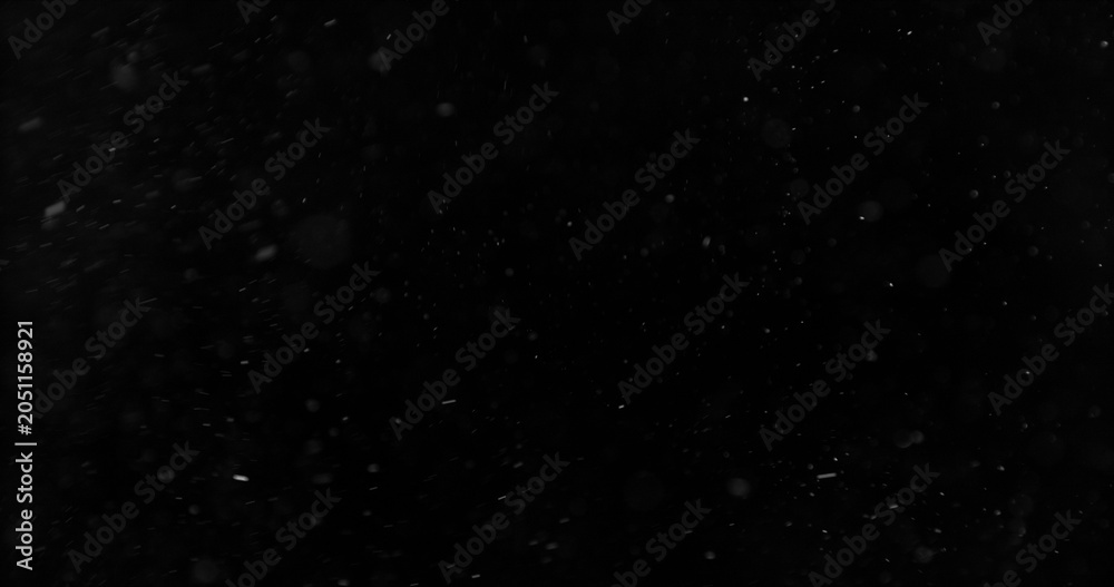 Fototapeta premium Realistic falling snow and airborne dust particles drifting through dark space. Atmospheric winter storm effect on black background, ideal for overlays, VFX compositing and cinematic scenes.