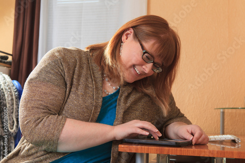 Woman who is legally blind using her tablet in her home