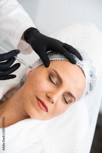 Cosmetic treatment with a woman receiving an injection in a clinic