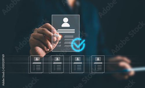 Businessman using stylus pen to evaluate candidates resume profiles for recruiting process. HR manager choosing standard resume for human resource hiring, talent acquisition and staffing concept
