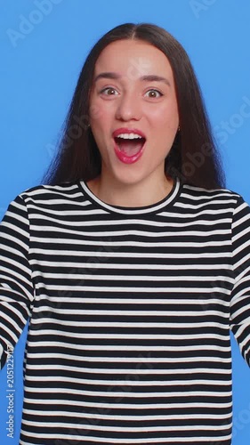 Oh my God, Wow. Excited amazed winner woman raising hands in surprise looking at camera with big eyes, shocked by sudden victory celebrating success achievement good news. Girl on blue background