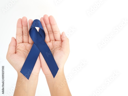 Woman holding blue ribbon for cancer awareness month. Healthcare and world cancer day concept.