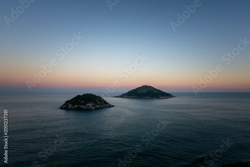 Fotografía Mar sereno e ilhas costeiras sob um céu de fim de tarde com cores suaves, Praia