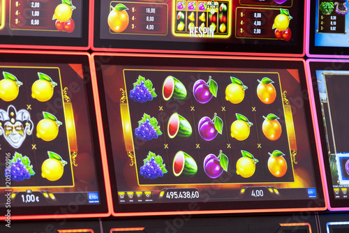 Casino slot machine digital screen displaying colorful spinning fruit symbols