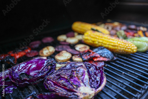 Farm fresh garden vegetables cooking on a pellet grill smoker for a vegetarian dinner. The healthy food is colorful and packed with vitamins and garden nutrients. Delicious!