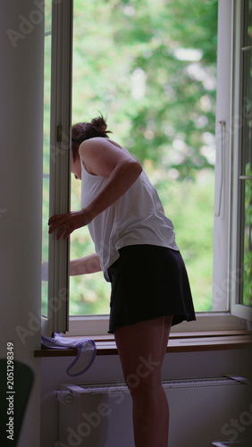 Woman cleaning window frame with cloth near open window at home, domestic maintenance and fresh air concept, everyday routine, hygiene and organized lifestyle