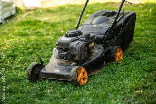 Lawn mower standing on freshly cut garden grass