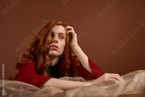Foto Elegant young man with long red hair showcases timeless fashion and charisma in
