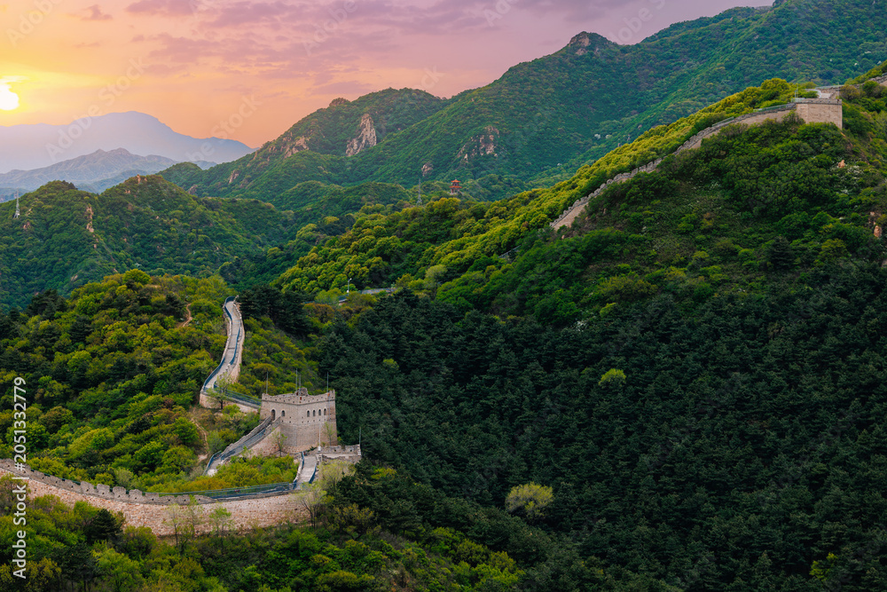Fototapeta premium Beijing, China Great wall curving over forested ridges at dusk