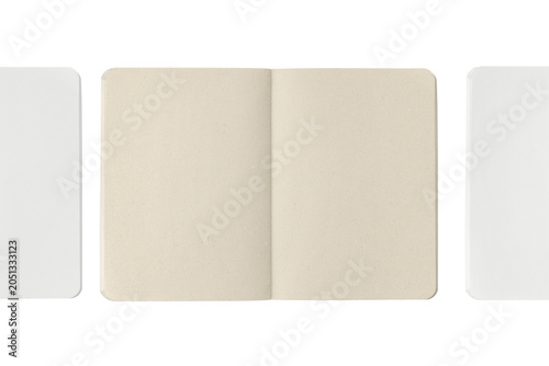 Three open notebooks side by side: a kraft paper notebook in the center, flanked by two white notebooks.