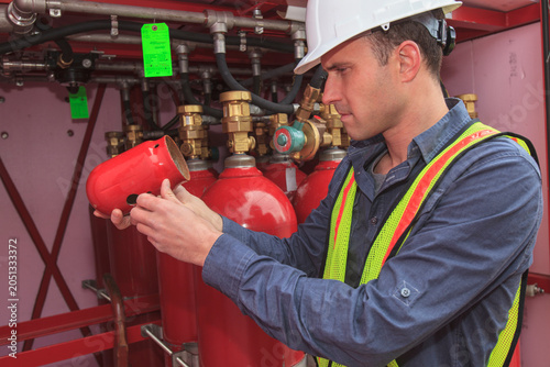 Industrial engineer examining cap for high pressure gas tanks at a power plant