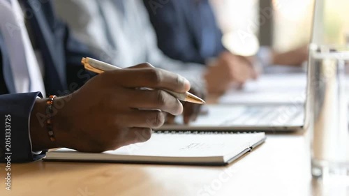A professional person writes notes during a business meeting in an office