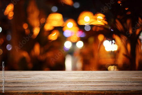 Wooden table and lights during night time. Product display or mockup