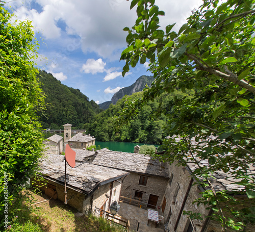 The stone facade of an ancient and beautiful house, stone roofs in the village of Isola Santa on the shore of the homonymous lake, magic in the heart of the Apuan Alps, in the province of Lucca