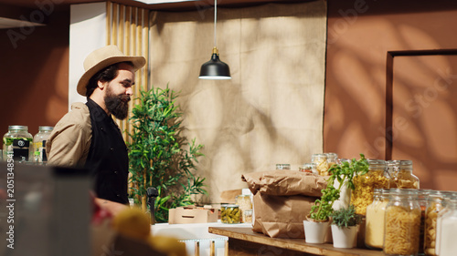 Принти на полотні Panning shot of bustling sustainable zero waste supermarket ran by zealous storekeeper, with local neighborhood store full with customers shopping for organic eco friendly produce
